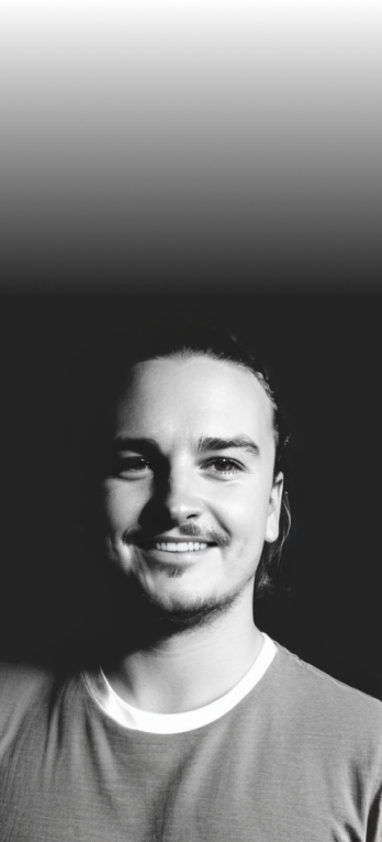 A headshot of Emil Backlund in black and white, smiling and looking directly at the camera. Image is AI generated with Stable Diffusion